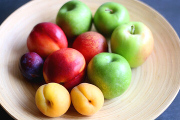 Wooden bowl with various colorful fruit. Selective focus.