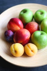 Wooden bowl with various colorful fruit. Selective focus.