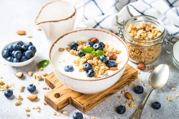 Yogurt with granola and fresh berries at stone table. Healthy food, snack or breakfast.