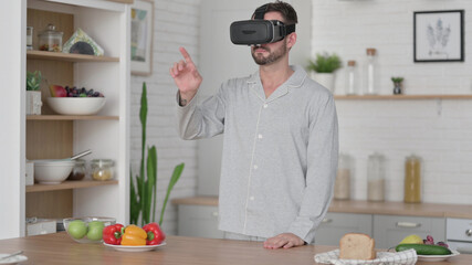 Modern Man using VR Set while Standing in Kitchen 