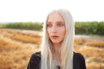 Outdoor portrait of young pretty girl with blonde hair, in the meadow.