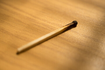 one used match on the brown wooden table.
