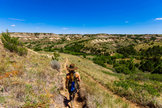 Woman hiking along The Petrified Forest Loop Trail inside Theodore Roosevelt National Park, North Dakota