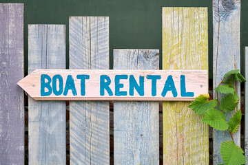 Sign with the inscription boat rental on a wooden fence on the river Spree in Berlin Kreuzberg in...