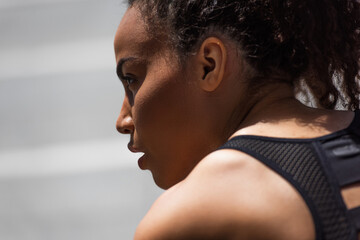 Obraz na płótnie Canvas Side view of african american sportswoman looking away