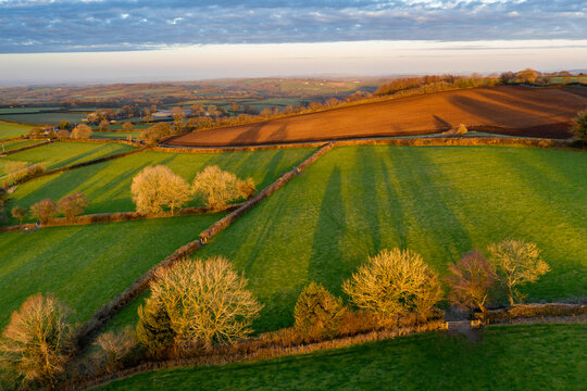 Aerial vista of Dartmoor countryside in rich evening sunlight in spring, Livaton, Devon, England