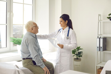 Woman doctor telling good treatment results giving support putting on shoulder to old man patient...