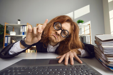Unhappy tired man stuck at work and can't go home. Desperate employee sitting chained to laptop computer and crying. Office slavery, nine to five job, technology addiction, working extra hours concept