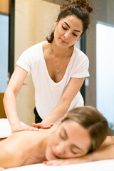 Obraz na płótnie Canvas Female masseuse giving a back massage to a woman in a beauty parlour.