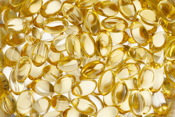 Golden fish oil capsules, vitamins isolated on a white background. Yellow fish oil in gelatin capsules. Fish oil pile.