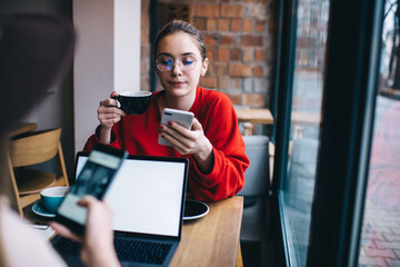 Focused woman browsing smartphone in cafe