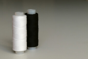 Black and white spool of sewing thread, side view