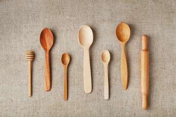 Wooden spoons made of natural wood on burlap fabric as a craft.