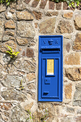 Since 1980 post boxes in Guernsey have been painted blue - This one is near Moulin Huet, Guernsey, Channel Islands UK