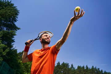 Male tennis player tossing the ball into the air © Viacheslav Yakobchuk