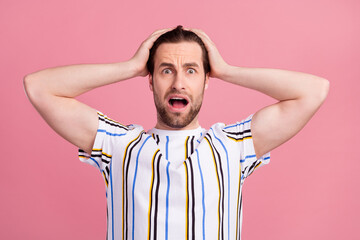 Photo portrait man in t-shirt shocked keeping head got problems isolated pastel pink color background