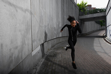 Fototapeta na wymiar Focused african american sportswoman training while running outdoors