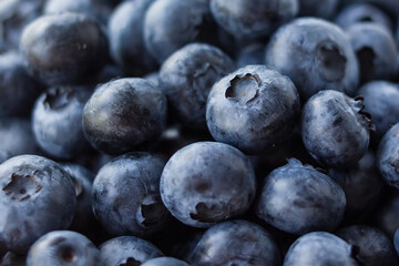 A lot of beautiful juicy fresh summer blueberries in a brown bag on a light background