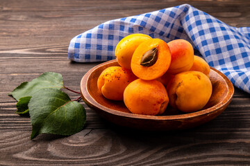ripe apricots in a bowl on wooden table
