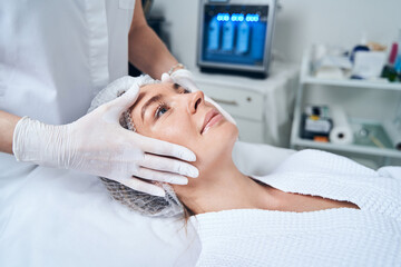 Obraz premium Positive delighted woman lying on couch during procedure