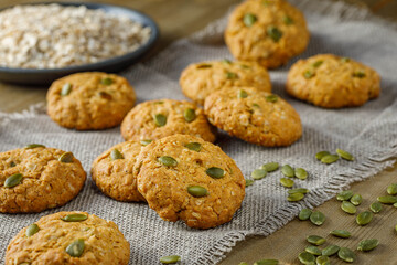 Fresh baked homemade oatmeal cookies with raisins and sunflower seeds on wooden background