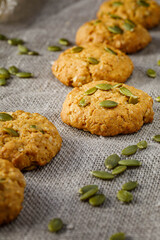 Fresh baked homemade oatmeal cookies with raisins and sunflower seeds on wooden background