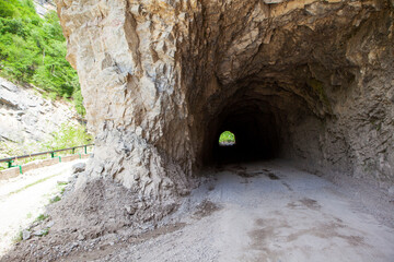 Obraz premium A tunnel made in the mountain and an old road around the mountain. Digorskoe gorge. North Ossetia. Russia.