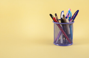 Colorful pen in metal pen pot. Pen in a holder basket.