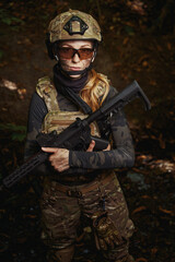 Serious female person holding gun with long barrel