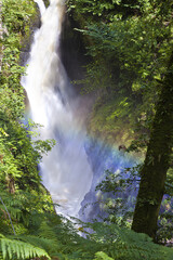 A rainbow over the Aira Force waterfall in the English Lake District at Ullswater, Cumbria UK