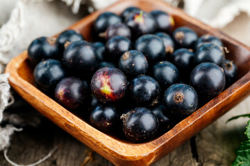Fresh black currant. A handful of berries on a wooden table