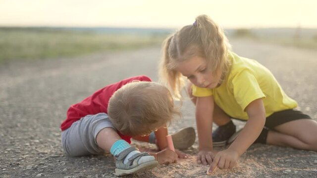 Happy child draw with chalk on asphalt in park. Child play and paint house and sun. Happy family concept Dream of home. Kid dream in park. Concept of kid dream of home. Chalk drawing of sun