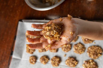 Liittle girl hands preparing oatmeal chocolate chips cookies