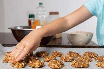 Liittle girl hands preparing oatmeal chocolate chips cookies