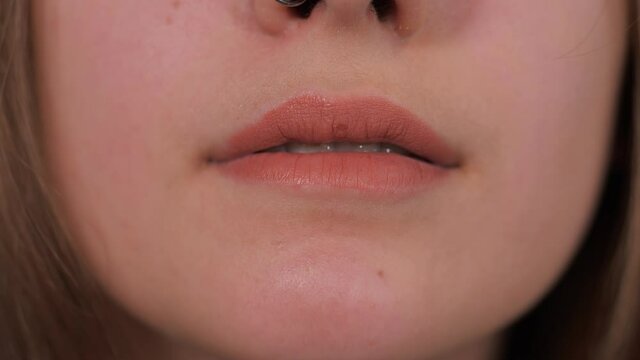 Woman bites her lower lip. Close-up