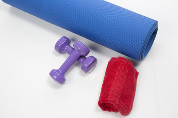 Yoga matt, dumbbells and a towel isolated on a white background