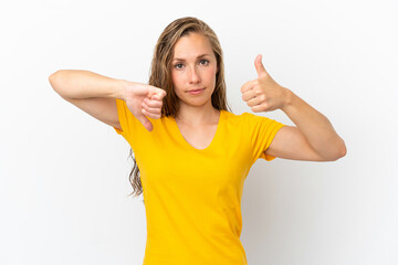 Young caucasian woman isolated on white background making good-bad sign. Undecided between yes or not