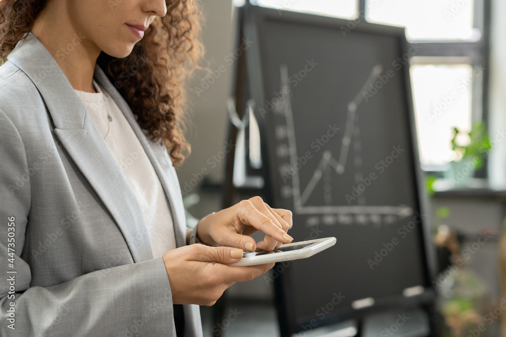 Poster young elegant bvusinesswoman pointing at tablet display while preparing for presentation