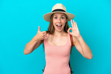 Young caucasian woman in summer holidays isolated on blue background showing ok sign and thumb up gesture