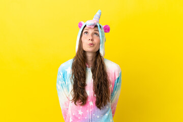 Girl with unicorn pajamas over isolated background and looking up