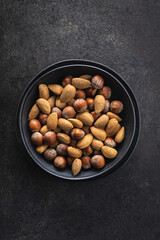 Unpeeled hazelnuts and almonds. Sweet nuts in bowl.