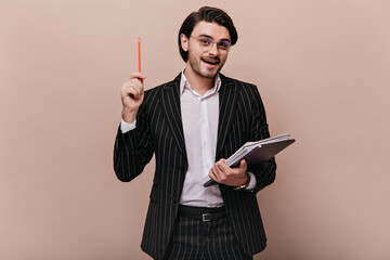 Elegant young teacher with brunette hair, in stylish light shirt, black striped suit, glasses...