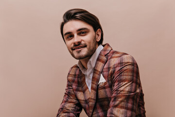 Close up portrait of cute young gentleman in retro plaid blazer and white shirt, looking straight...