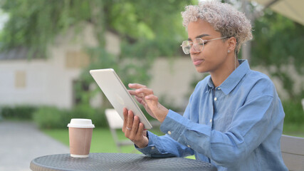 African Woman using Tablet in Outdoor Cafe 