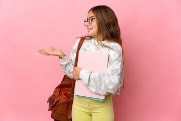 Student little girl over isolated pink background with surprise expression while looking side