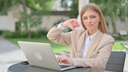 Thumbs Down by Businesswoman with Laptop in Outdoor Cafe 