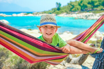 happy child by the sea on hammock in greece background