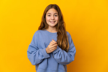 Child over isolated yellow background laughing