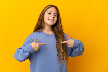 Child over isolated yellow background proud and self-satisfied