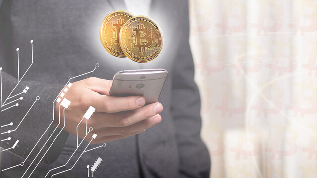 Moneda de oro de Bitcoin sobre tel&eacute;fono m&oacute;vil en tono claro, fondo blanco hombre con traje de negocios